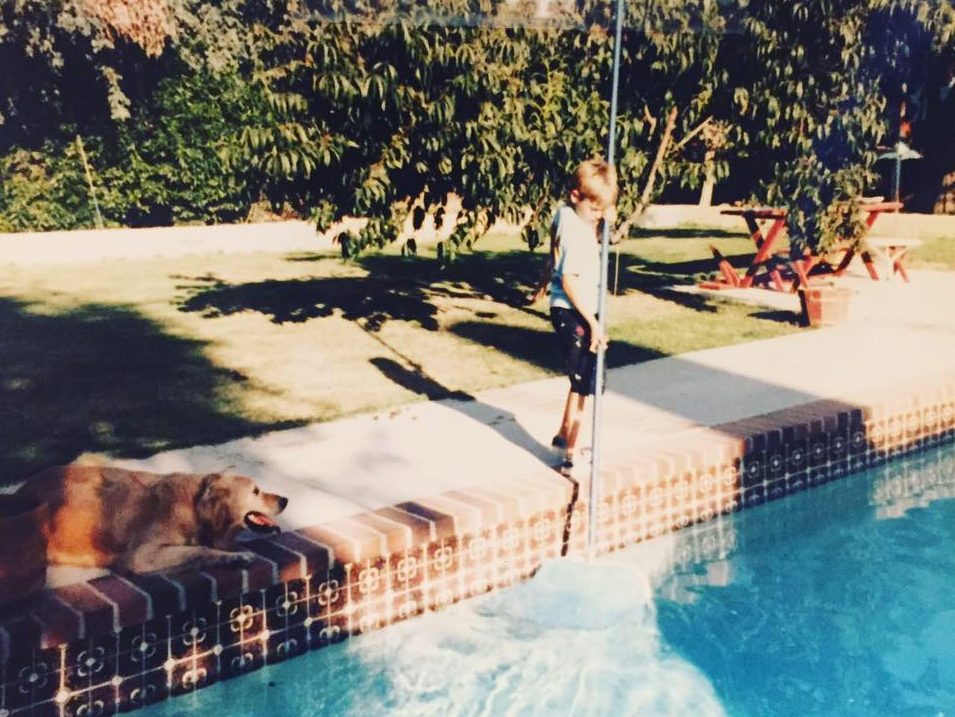Brent Pascoe at age 9 cleaning his first pool with the family dog